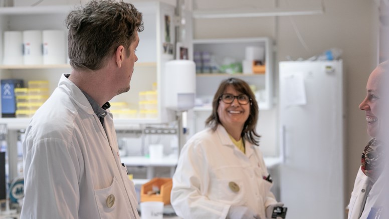 En veterinär pratar med kollegorna på labb.