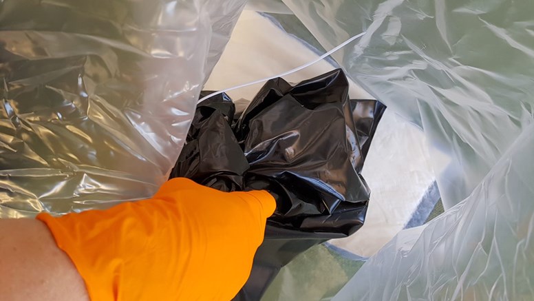 Lägg absorberande material i botten av plastsäck 2 och stoppa i plastsäck 1. Förslut med buntband (vik och förankra toppen med ett hårt åtdraget buntband).